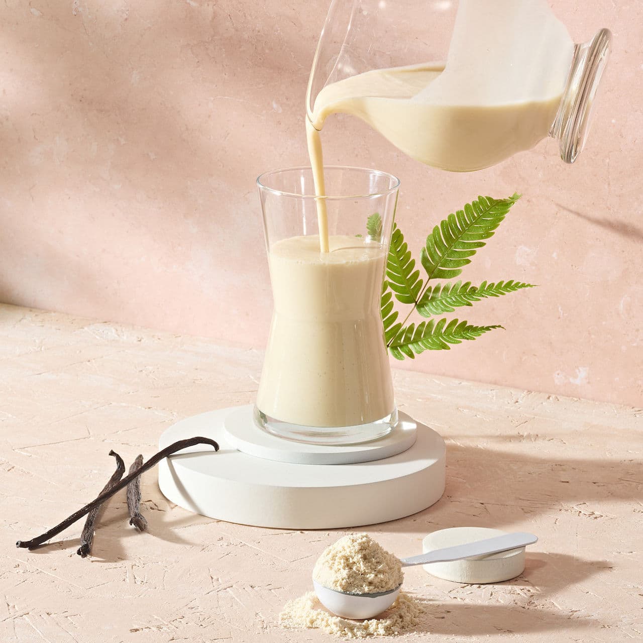 Protein Drink Mix Vegan preparato con acqua in un bicchiere.